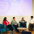 four speakers on a panel discussion at a conference