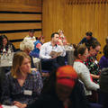 Audience members sat at tables at a conference 