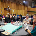 Conference attendees sat around a table in discussion and writing on a poster