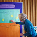 A woman contributing to an interactive feedback poster